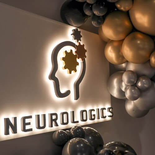 Neurologics logo surrounded by colorful balloons in gold and silver, symbolizing celebration and innovation in neuroscience.